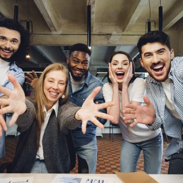 Happy overjoyed business team celebrate corporate victory in their office